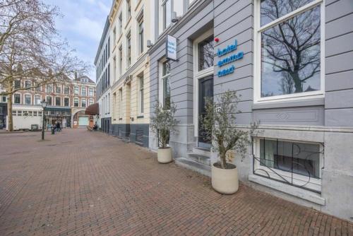 a city street with buildings and potted plants on the sidewalk at hotel emma next in Rotterdam