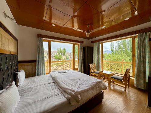 a bedroom with a bed and a large window at Hinjuma guest house in Leh