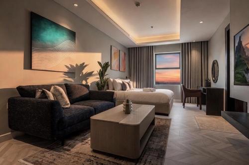 a living room with a couch and a bed at Stella Stays Olaya Tower 1 - Furnished Apartments in Riyadh