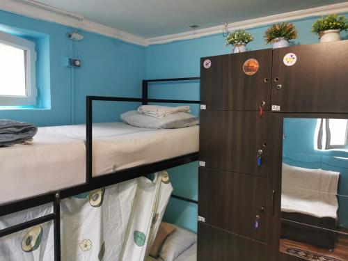 two bunk beds in a room with blue walls at Harmony Backpackers Hostel in Batumi