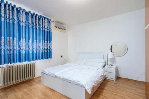 a bedroom with a bed and a blue curtain at Byty Na vyhlídce in Zdice