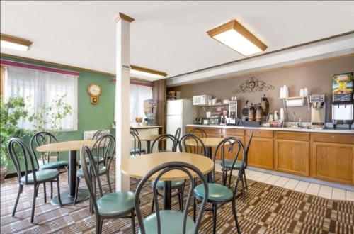 a restaurant with tables and chairs and a kitchen at Mid Rest Inn Lexington NE I-80 in Lexington