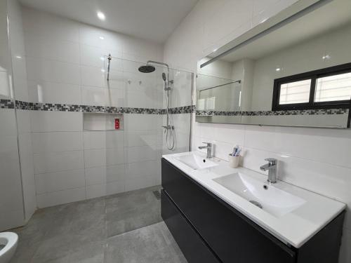 a white bathroom with a sink and a shower at Le Welcome Almadies in Ngor