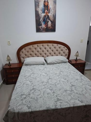 a bedroom with a large bed with a large headboard at confortável suite no jardim Botânico in Ribeirão Preto