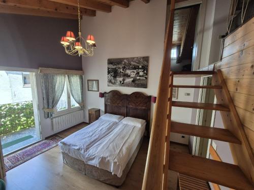 a bedroom with a bed and a staircase in it at Foresteria Traversi in Berbenno di Valtellina