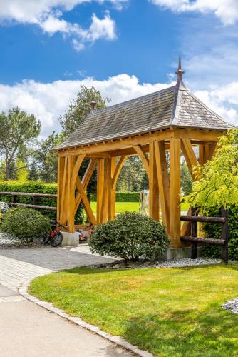 a wooden gazebo in the grass in a park at Confidentiel in Goven