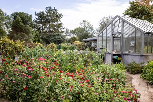 a greenhouse in a garden with flowers at Confidentiel in Goven