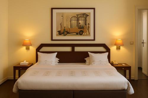 a bedroom with a large bed with a picture on the wall at Hotel Du Parc - Mulhouse Centre in Mulhouse