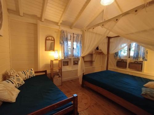 a bedroom with a canopy bed and windows at Blue Kaz Caraïb in Pointe-Noire