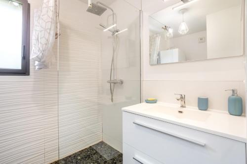 a white bathroom with a sink and a shower at Villa Les Lodges Terre et Mer in Concarneau