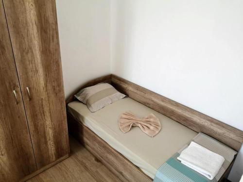 a small bed with a bow tie on it at Къща за гости ПЕРФЕКТО in Chernomorets