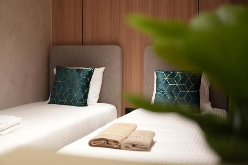 a hotel room with two beds with towels on them at Central Lux in Petrovac na Mlavi
