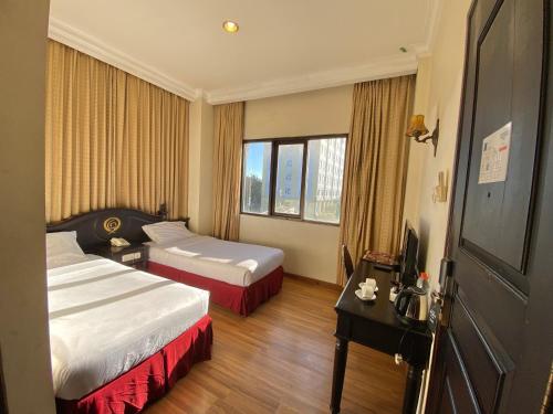 a hotel room with two beds and a television at Quds Royal Hotel in Surabaya