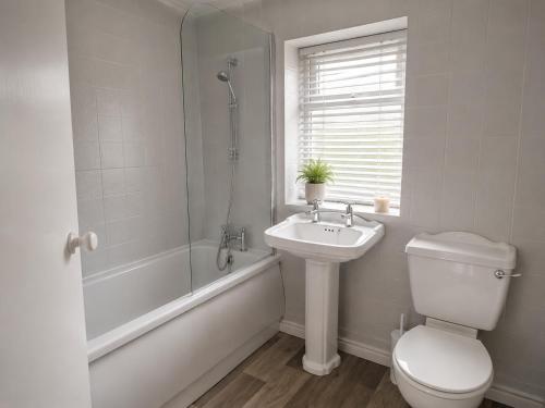 a bathroom with a toilet and a sink and a shower at Amy's place in Warrington