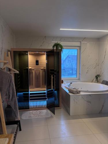 a large bathroom with a tub and a window at Secret Place apartments, luxury and spa in Zdenci Brdovečki