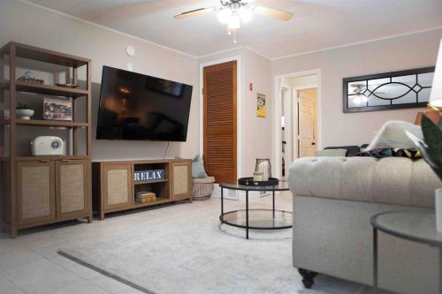 a living room with a couch and a flat screen tv at Cozy 3BR Coastal Retreat Private Yard & Fire Pit 5 Min to Beach! in Old Orchard Beach