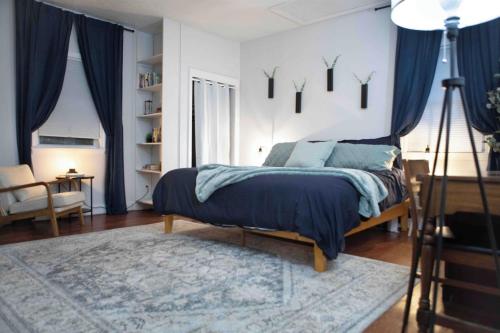 a bedroom with a bed with a blue comforter at Cozy 3BR Coastal Retreat Private Yard & Fire Pit 5 Min to Beach! in Old Orchard Beach