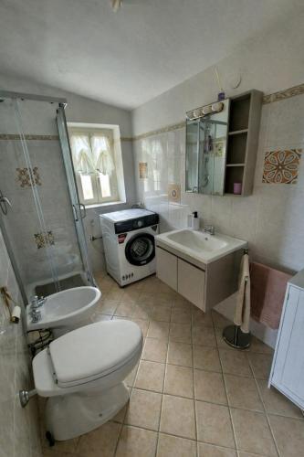 a bathroom with a toilet and a sink and a shower at Sogni appesi in Valleluce-Cese