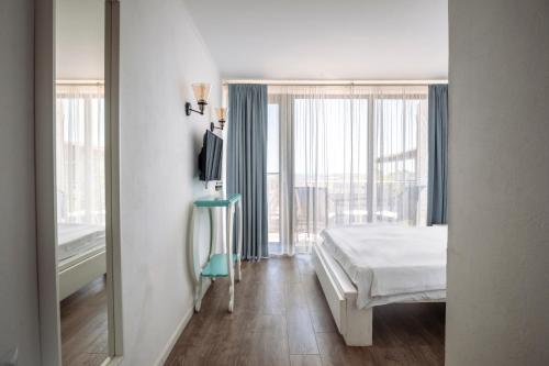 a bedroom with a bed and a large window at The Moon Vama Veche in Vama Veche