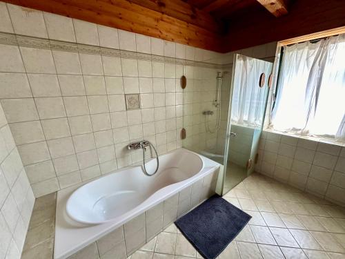 a white tub in a bathroom with a window at Apkó Vendégház in Őriszentpéter
