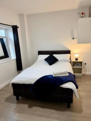a bed with a black headboard in a bedroom at Accessible Town Centre 1 bed Flat Kettering Wi-FI in Kettering