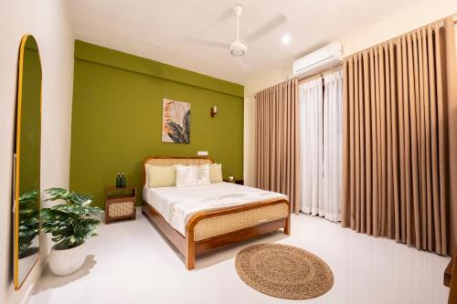 a bedroom with a bed and a green wall at 79 by TerraLume in Nugegoda