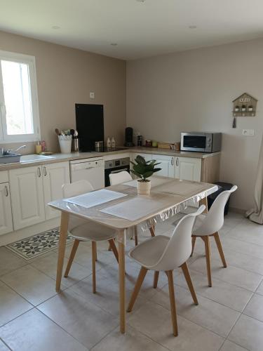 a kitchen with a table and chairs in a kitchen at Charmant cocon tout équipé in Carpentras