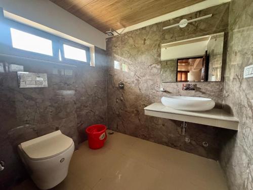 a bathroom with a toilet and a sink and a mirror at Hinjuma guest house in Leh