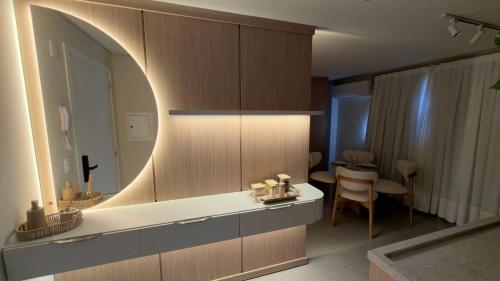 a bathroom with a counter with a mirror and a table at Studio 48 - Lindo apto Studio no centro de Foz in Foz do Iguaçu