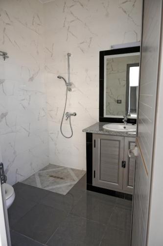 a bathroom with a shower and a sink and a mirror at Maison 100 in Douz