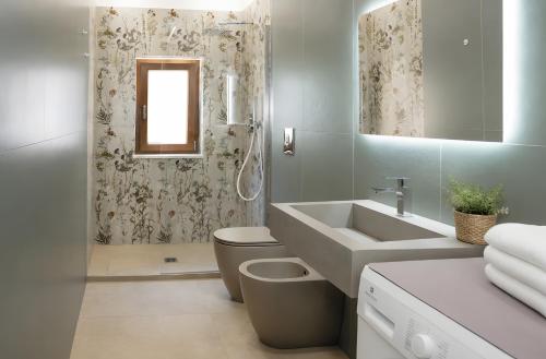 a bathroom with a sink and a toilet and a mirror at Casa vacanza Via Roma 103 in Crotone