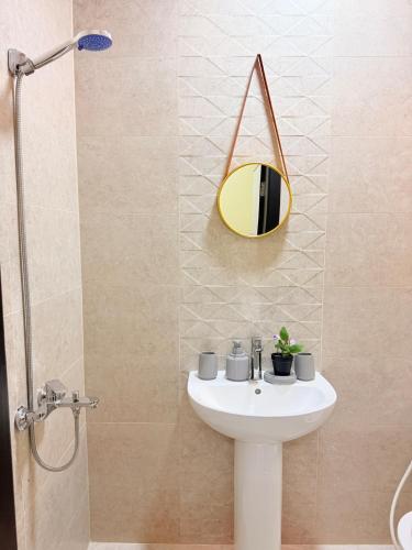 a bathroom with a sink and a mirror on the wall at Modern Studios Apartments in Juffair and Exhibition in Manama