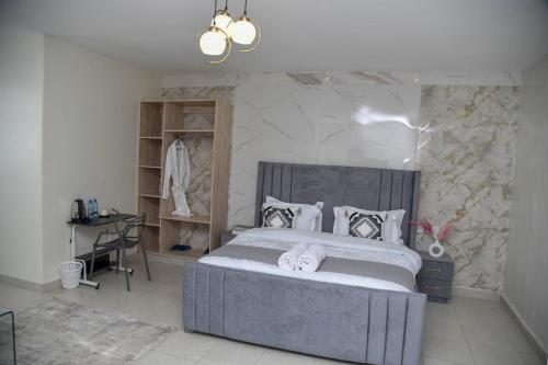 a bedroom with a large bed and a desk at The Premier Comfort in Nairobi
