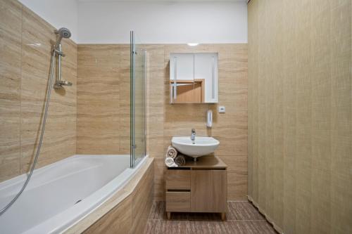 a bathroom with a tub and a sink and a shower at Apartment Absolon in Komín