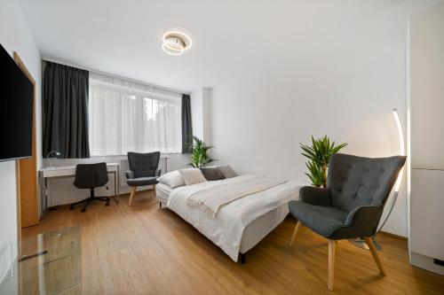 a bedroom with a bed and two chairs and a desk at Apartment Absolon in Komín