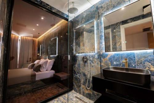 a bathroom with a sink and a shower at Cuni Luxury Hotel in Sarandë