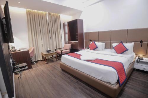 a hotel room with a large bed and a television at Spree Manor Hotel in Aurangabad