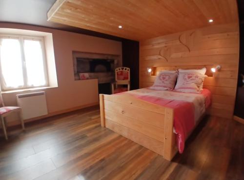 a bedroom with a wooden bed with a wooden floor at Entre-parenthèses,gîte avec SPA,proche Gérardmer et La bresse in Vagney