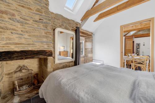 a bedroom with a bed and a stone wall at Gite Ti Arzou in Le Conquet