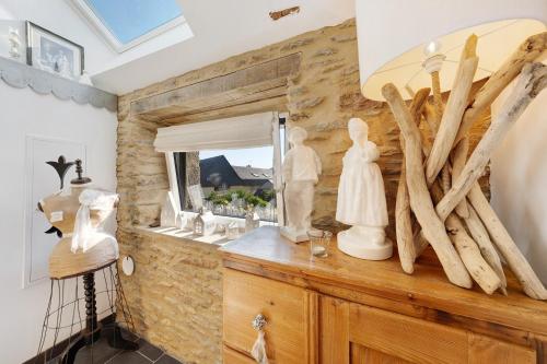 a room with a mirror and some statues on a dresser at Gite Ti Arzou in Le Conquet