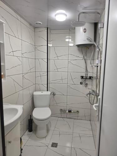 a white bathroom with a toilet and a sink at Апартамент Туида 2 in Sliven