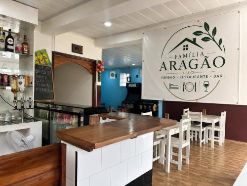 a bar in a restaurant with a sign at Pensão Aragão & Lima in São Tomé