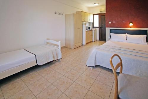 a hotel room with two beds and a kitchen at Studios Stella Vourvourou in Vourvourou