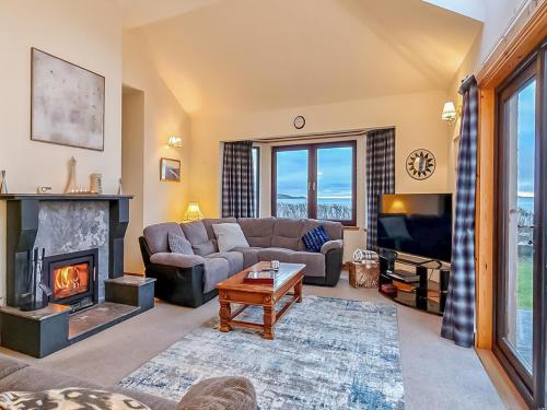 a living room with a couch and a fireplace at Sealladh Lingeigh in Pollachar