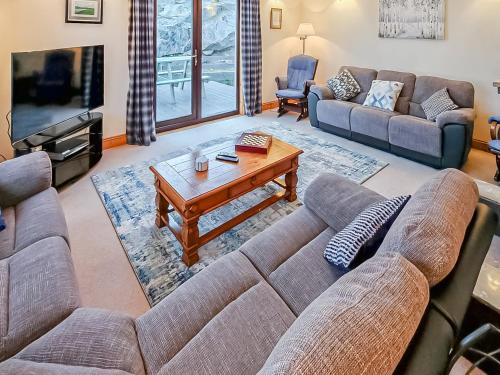 a living room with a couch and a coffee table at Sealladh Lingeigh in Pollachar