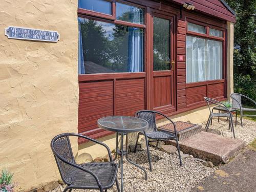 a group of chairs and a table in front of a building at Sandy Cott in Kilkhampton