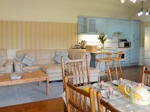a living room with a couch and a table at Kinnelhook Holiday Cottage in Templand