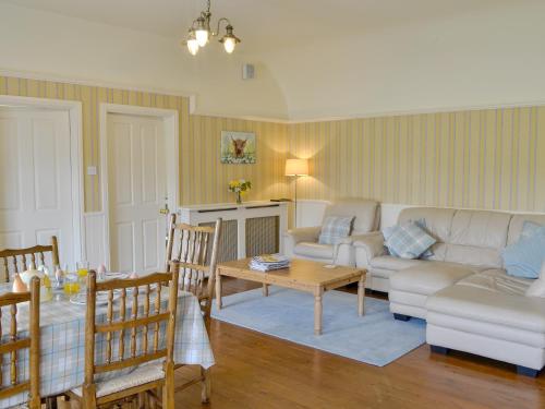 a living room with a couch and a table at Kinnelhook Holiday Cottage in Templand