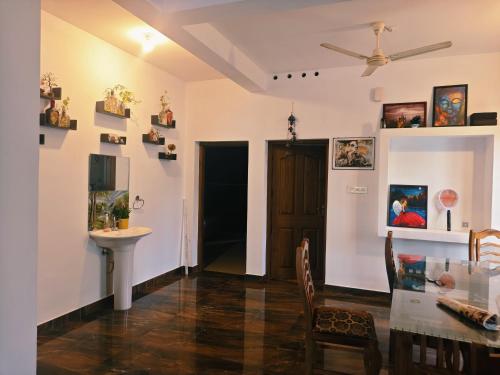 a dining room with a table and a sink at Phoenix homestay in Varkala