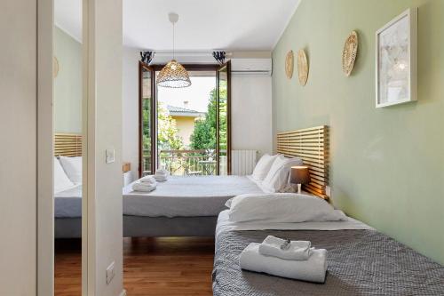 a bedroom with two beds and a balcony at Bc Garda House in Peschiera del Garda
